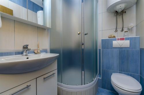 a bathroom with a shower and a toilet and a sink at Apartments Bluesun in Omiš