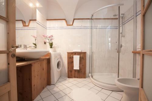 een badkamer met een douche, een wastafel en een toilet bij Casa Melide 3 in Bormio