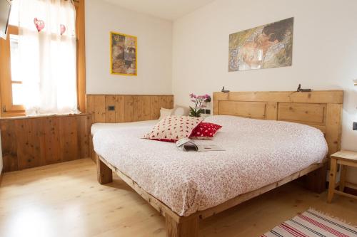 a bedroom with a large bed with red pillows at Casa Melide 3 in Bormio