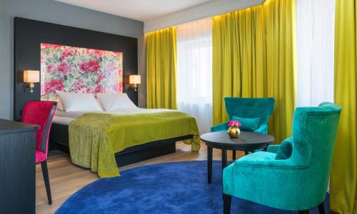 a hotel room with a bed and colorful chairs at Thon Hotel Arendal in Arendal