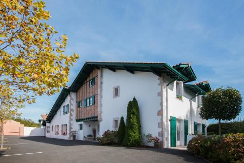 un grand bâtiment blanc avec un toit dans l'établissement Maison d'hôte Iparra- Pays Basque, à Arcangues