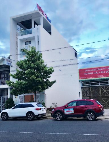 two cars parked in front of a white building at Truong Ca Hotel in Phan Thiet