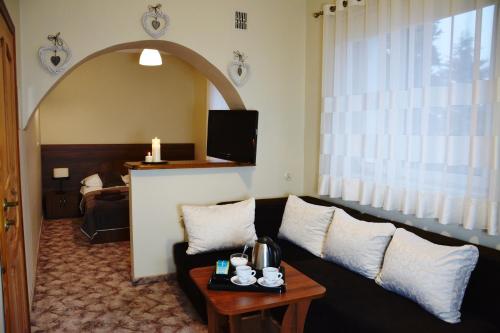 un soggiorno con divano e tavolo di Hotel Irena a Morąg