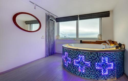 June street Spa apartments في فيلنيوس: حمام مع حوض في غرفة مع نافذة