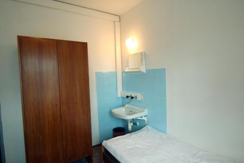 mała łazienka z umywalką i łóżkiem w obiekcie Hotel Medlov Depandance w mieście Fryšava