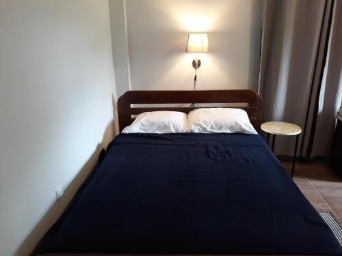 a bed in a small room with a blue blanket at Waterland Suites in Paramaribo