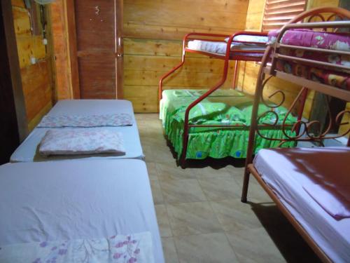 a room with two bunk beds in a cabin at Hostal Villas Mexico in San Juan del Sur