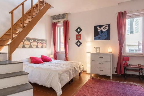 a bedroom with a bed with red pillows and a staircase at Penthouse with Terrace in the Heart of Rome in Rome