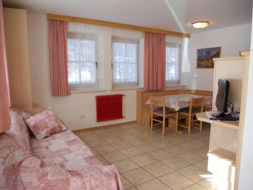 a living room with a couch and a table at Casa El Tobià in Pozza di Fassa