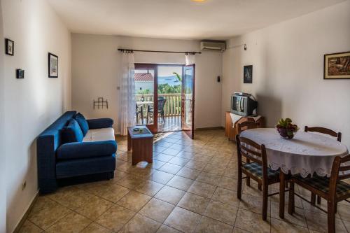 - un salon avec un canapé bleu et une table dans l'établissement Apartments Adria, à Biograd na Moru