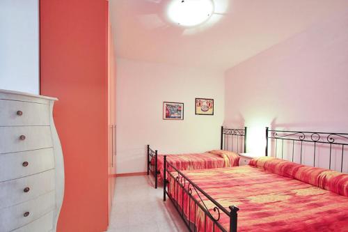 una camera con due letti e un comò di Condominio Casamare a Lignano Sabbiadoro