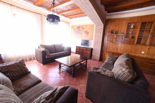 a living room with two couches and a table at Casa rural Vistas al Rio in Jorquera
