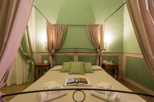 a bedroom with a canopy bed with a book on it at La Bohème in Lucca