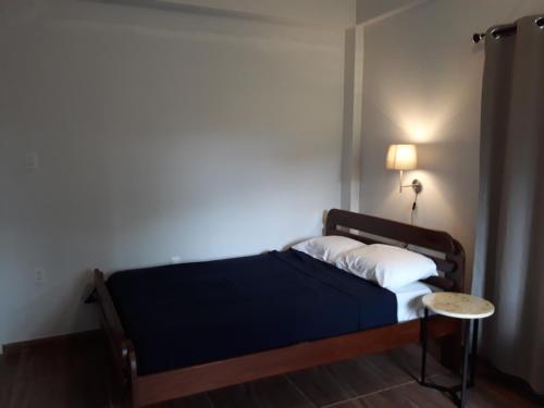 a small bedroom with a bed and a table at Waterland Suites in Paramaribo