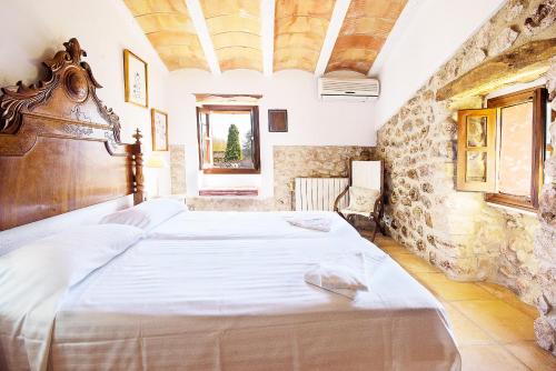 a bedroom with a large bed in a stone wall at VILLA L'Hort - Traditional restored house in Pollença