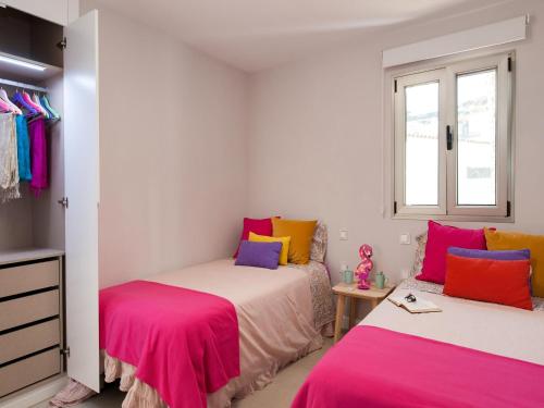 2 camas en una habitación de color rosa y amarillo en Bungalow Playa del Aguila II over the sea, en Playa del Águila