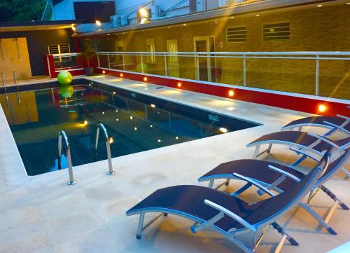 - deux chaises assises à côté de la piscine la nuit dans l'établissement L'Eskale Guyane, à Montjoly