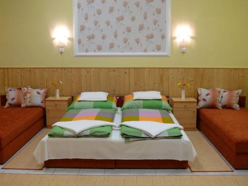um quarto com 2 camas individuais e um quadro na parede em Madácsi Vendégház em Kiskorös