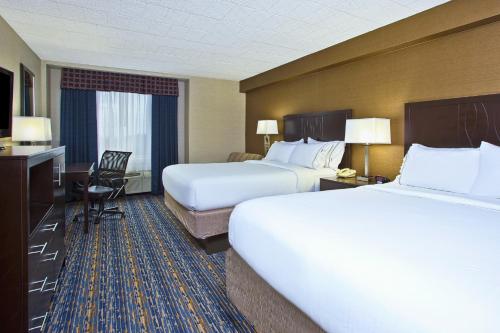 a hotel room with two beds and a desk at Holiday Inn Express and Suites Pittsburgh West Mifflin by IHG in West Mifflin