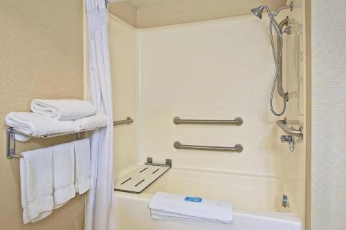 y baño con ducha, bañera y toallas. en Holiday Inn Express and Suites Pittsburgh West Mifflin, an IHG Hotel, en West Mifflin