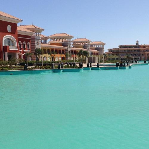 a large pool of blue water in front of buildings at Chalets in Porto Sharm - Families Only AN in Sharm El Sheikh
