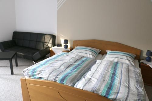 a bed in a living room with a couch and a bed sidx sidx sidx at Pension Garni Haus Bismarckhöhe in Bad Ems