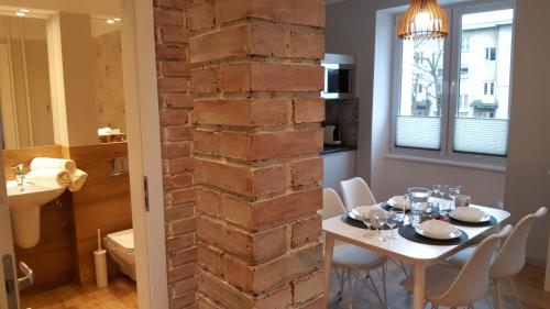 a dining room with a table and a brick wall at Studio Centrum Ratusz in Częstochowa