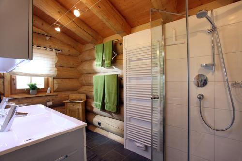 ein Badezimmer mit Dusche und Waschbecken in der Unterkunft Blockhaus Chalet Heim in Kirchberg in Tirol