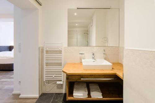 a bathroom with a sink and a mirror at Kaiser Max Design Appartements in Innsbruck
