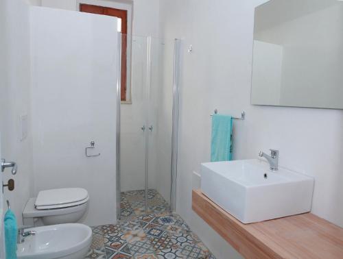 bagno bianco con lavandino e servizi igienici di Villa Gio a Torre Suda