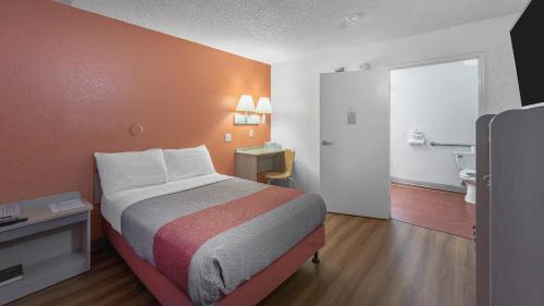 a small hotel room with a bed and a bathroom at Motel 6-Medford, OR - North in Medford
