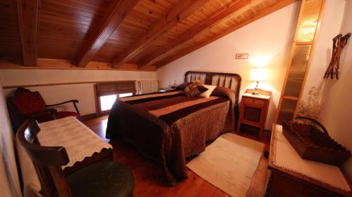 een slaapkamer met een bed en een houten plafond bij Casa Maria Jesus in Mosqueruela