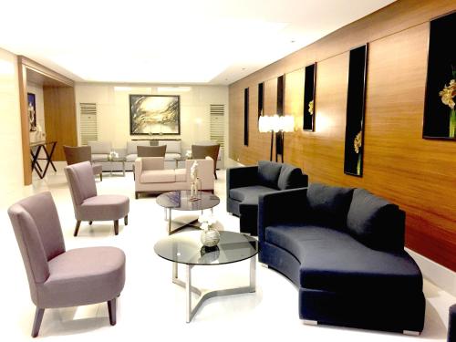 a living room with couches and tables and chairs at Sea Breeze Studio Manila in Manila