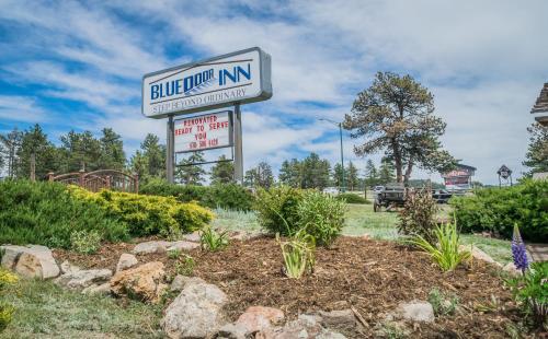 un panneau indiquant un bâtiment dans un jardin dans l'établissement Blue Door Inn, à Estes Park