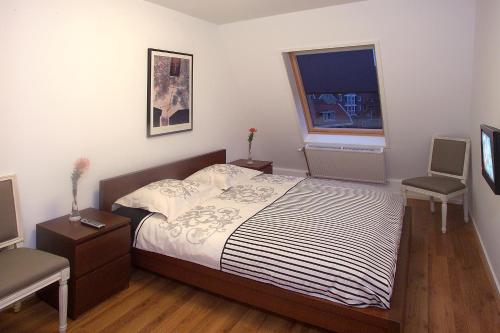 Schlafzimmer mit einem Bett und einem Fenster in der Unterkunft Floli Gasthuis in Volendam