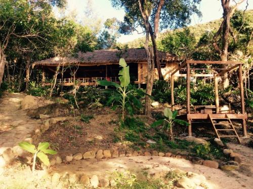 a house in the woods with a pond in front of it at Robinson Bungalows in Koh Rong Sanloem