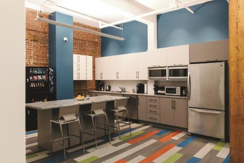a kitchen with white cabinets and a large island with bar stools at Granville Hall Residence in Halifax