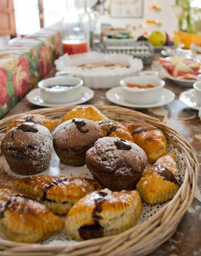 a table topped with a basket of pastries and muffins at Le Terrazze Del Chianti b&b Residenza d'Epoca e di Charme in Tavarnelle in Val di Pesa