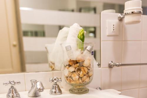 a glass vase filled with nuts sitting on a bathroom sink at VENETO COMFORTABLE Apartment in Rome