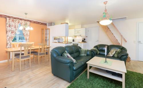 a living room with a leather couch and a table at Norrö Holiday Village in Bamböle