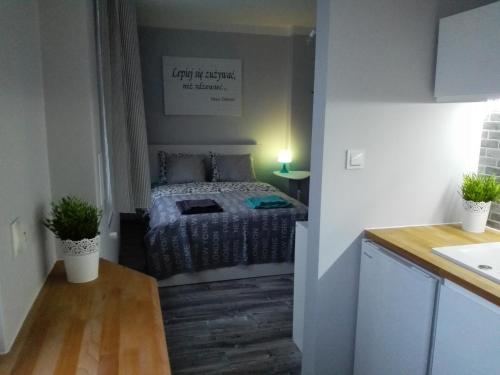 a small bedroom with a bed in the corner at Grey Apartament Centrum Gdynia in Gdynia