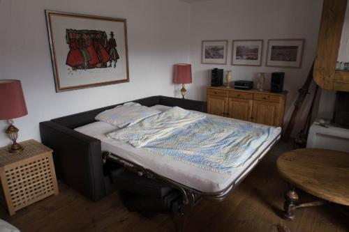 a bed in a room with a table and two lamps at Chesa Mutaun in Silvaplana