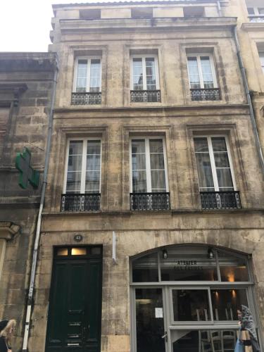 un edificio con una puerta verde y ventanas en Appartements Bordeaux Saint Michel en Burdeos