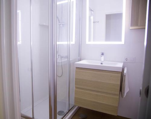 biała łazienka z prysznicem i umywalką w obiekcie Las Palmas BEACH w mieście Las Palmas de Gran Canaria