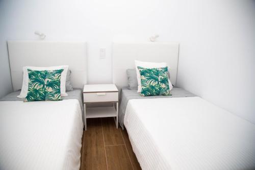 2 łóżka w małym pokoju z białymi ścianami w obiekcie Las Palmas BEACH w mieście Las Palmas de Gran Canaria