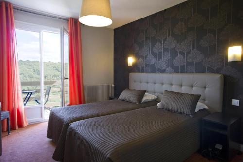 two beds in a bedroom with red curtains and a window at Auberge Du Camp Romain in Chassey-le-Camp