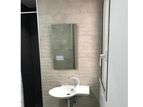 ein Badezimmer mit einem weißen Waschbecken und einem Spiegel in der Unterkunft Smart Tech Plaza Flat in Salamanca