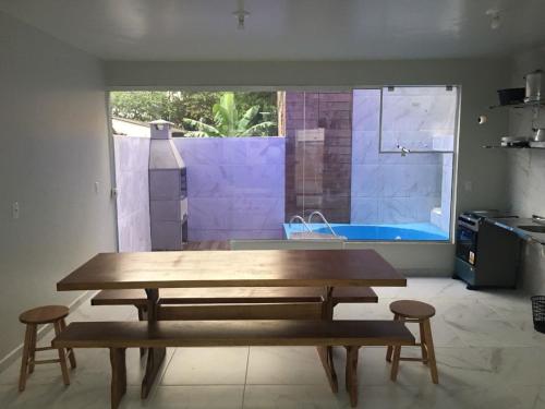 una mesa y dos taburetes en una cocina con piscina en RL - CASA PISCINA PRIVATIVA 4 SUITES, AR SPLIT, WI-FI, ATE 16 PESSOaS BRUNO KLEMTZ, en Itapema