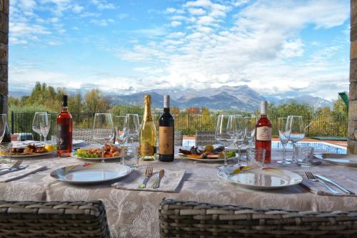 a table with wine bottles and plates of food at Villa Artemia in Manerba del Garda
