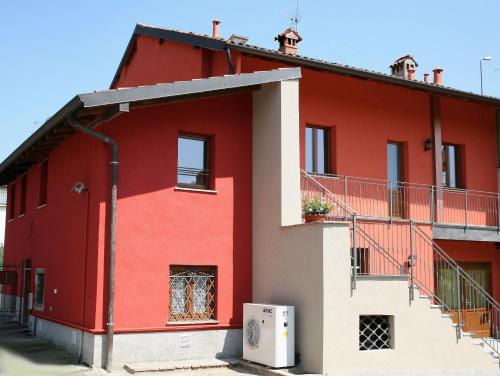 a red and white house with a balcony at BORGHETTO AIRPORT/HOSPITAL in Bergamo
